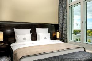 a bedroom with a large bed with a large window at Hotel Atlantic Hamburg, Autograph Collection in Hamburg