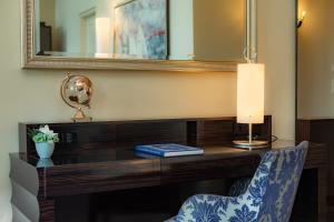 a desk in a room with a mirror and a chair at Hotel Atlantic Hamburg, Autograph Collection in Hamburg