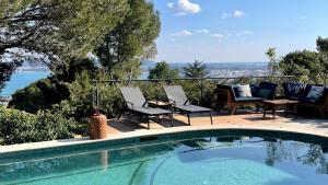 - une piscine avec des chaises et une vue sur l'eau dans l'établissement La Singulière, à Sète