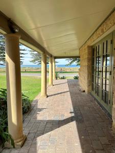 a porch of a building with columns on it at Ardgreian in Safety Bay