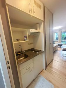uma pequena cozinha com um lavatório e um fogão em Messe Flughafen nah mit Waschmaschine em Dusseldorf