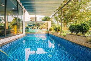 a swimming pool in a building with a mural at Villa FLC Sầm Sơn Thanh Hoá in Sầm Sơn