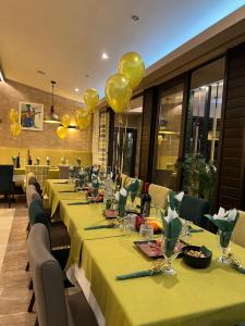 eine Reihe von Tischen mit gelben Ballons in einem Restaurant in der Unterkunft Family Hotel Ognyanovo in Ognyanovo