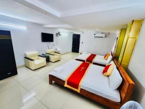 a bedroom with two beds and a television in it at Istars Hotel in Ho Chi Minh City