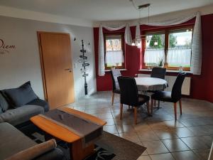 a living room with a couch and a table and chairs at Ferienwohnung Mause in Medebach