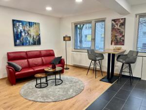 a living room with a red couch and a table at RUEHOME in Essen