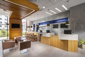 an office lobby with a reception desk and chairs at Comfort Hotel Olomouc Centre in Olomouc