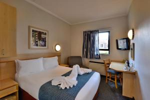 Road Lodge Centurion في سنتوريون: غرفة في الفندق مع سرير ومكتب