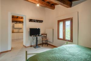 1 dormitorio con 1 cama y TV y cocina en La rosa del vento, en Fabbriche di Vallico