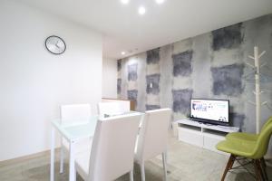 een eetkamer met een tafel en een computer aan de muur bij Tsuruhashi East III in Osaka