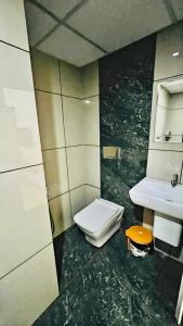 y baño con aseo y lavamanos. en Elenji Vitara Resort Munnar en Munnar