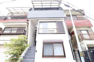 een wit huis met trappen en ramen bij Tsuruhashi East III in Osaka