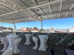 a row of white tables and chairs on a roof at Villa Verona in Guatemala