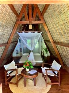 an attic room with a table and chairs and a ceiling at Aurora Lodge in Ile aux Nattes