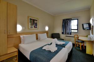 Una habitación de hotel con una cama con toallas. en Road Lodge Centurion en Centurion