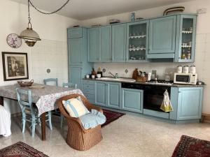 a kitchen with blue cabinets and a table with chairs at Relax in Canavese in Vestignè