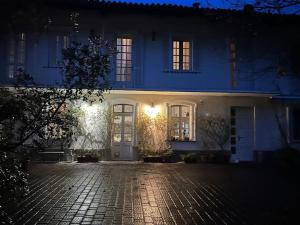 Vestignè的住宿－Casa Relax in Canavese，夜间白色的房子,有鹅卵石车道
