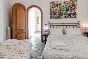 - une chambre avec 2 lits et un tableau mural dans l'établissement Great Apartment at the Duomo, à Florence