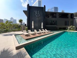 une piscine avec des chaises longues et un bâtiment dans l'établissement Frank Porter - Ahad Residences, à Dubaï