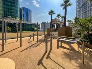 杜拜的住宿－Frank Porter - Ahad Residences，棕榈树阳台的长凳和建筑