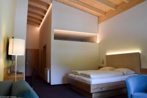 a bedroom with a bed in a room with wooden ceilings at Hotel Forelle in Plansee