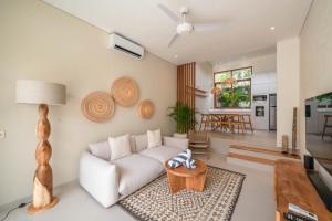 ein Wohnzimmer mit einem weißen Sofa und einem Tisch in der Unterkunft Villa Inka - Tropical Modern 1BR Villa in Pererenan Beachside in Canggu