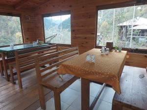 uma sala de jantar com uma mesa e bancos numa cabina em Gogalay Bungalov Hotel -Restoran em Artvin