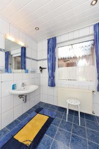 a blue and white bathroom with a sink and a mirror at Ferienwohnungen im Haus Nordseebrise in Neuharlingersiel +32 photos