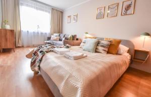 a large bed in a living room with a couch at Apartamenty na Wyspie - Zdrojowa in Świnoujście