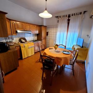 una cucina con tavolo e sedie e una cucina con tavolo e una cucina di Casa Anselmo Guest House a Pagani