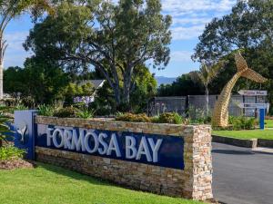 un panneau indiquant la baie de tomosias dans un parc dans l'établissement Formosa Bay, à Plettenberg Bay