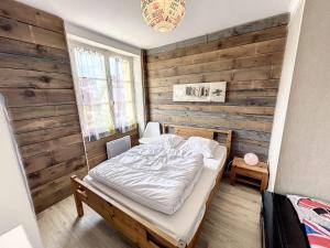 ein Schlafzimmer mit einem Bett und einer Holzwand in der Unterkunft Maison Jullouville, 5 pièces, 9 personnes - FR-1-361-15 in Jullouville-les-Pins