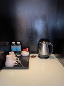 una encimera de cocina con tetera y botellas de agua en Merchant Hotel, en George Town
