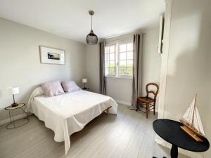 1 dormitorio con cama blanca y ventana en Maison Saint-Pair-sur-Mer, 5 pièces, 8 personnes - FR-1-361-56 en Saint-Pair-sur-Mer
