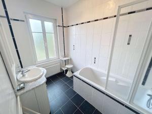 a bathroom with a sink and a tub and a toilet at Maison à 100m de la plage, jardin privé, wifi gratuit, proche commerces et activités balnéaires - FR-1-361-113 in Jullouville-les-Pins +11 photos