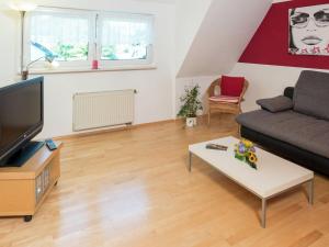 een woonkamer met een bank en een tafel bij Cozy Apartment in Schwenningen with Garden in Villingen-Schwenningen