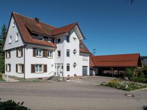 フィリンゲン・シュヴェニンゲンにあるCozy Apartment in Schwenningen with Gardenの茶色の屋根の大白い家