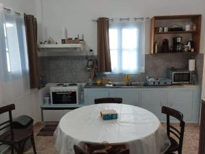 a kitchen with a table with a white table cloth on it at Calliope's house in Lipsoi