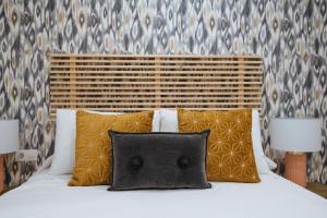 1 dormitorio con 1 cama con 2 almohadas y 2 lámparas en Wish Suite Miraflores de Sevilla, en Sevilla