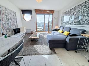 een woonkamer met een blauwe bank en een tv bij Appartement Granville, 1 pièce, 2 personnes - FR-1-361-337 in Granville