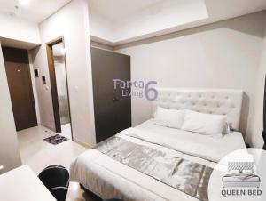 um quarto com uma cama grande e uma mesa em Complete ALL-IN-ONE Studio Apartment Taman Anggrek Residence at CENTRAL CITY near Malls em Jakarta