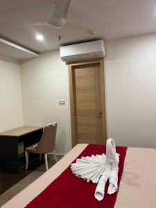 a room with a bed with white towels on it at Royal Orbit in Jabalpur