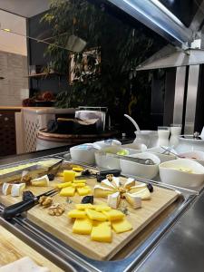 Ein Haufen Käse auf einem Schneidebrett in einer Küche in der Unterkunft VENEZIANA Boutique Hotel Superior in Koper