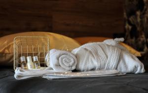 a pile of towels and cosmetics on a bed at Le Premium - Suite Spa Privatif in Pontavert