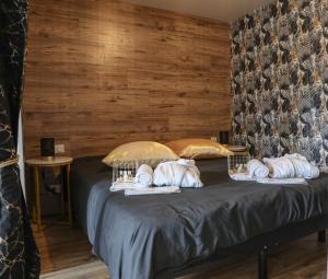 a bedroom with a bed with a wooden wall at Le Premium - Suite Spa Privatif in Pontavert +23 photos