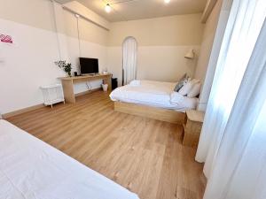 Dormitorio pequeño con cama y TV en La Moon House en Salaya