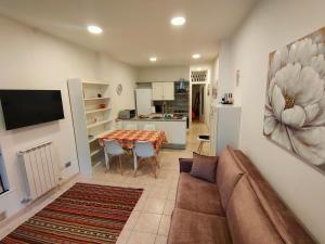 a living room with a couch and a table and a kitchen at Discesa Marina in Ventimiglia