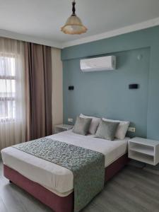 een slaapkamer met een groot bed met blauwe muren bij Kusadasi Sezgins Boutique Rooms in Kuşadası