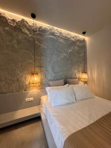 a bedroom with a bed with two lights on the wall at Poema Antiparos in Antiparos