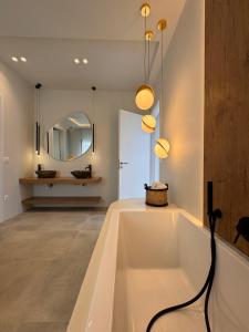 a bathroom with a bath tub and a mirror at Poema Antiparos in Antiparos